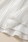 Plisseekleid Rozalia in Weiß – plissierter Rock und glattes Futter – Detailaufnahme